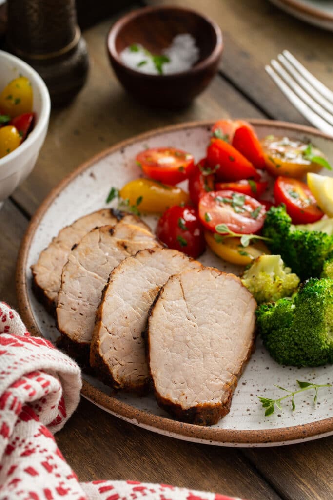 Sliced pork tenderloin served with fresh tomatoes and steamed broccoli.