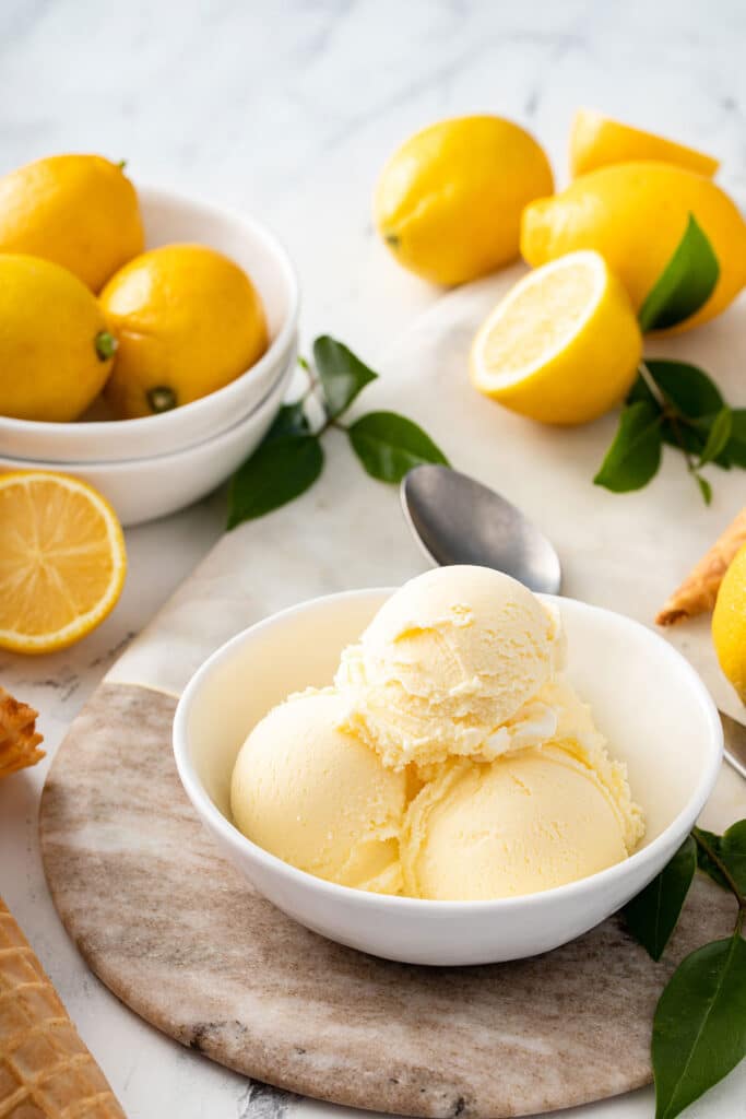 A white bowl with 3 scoops of lemon ice cream