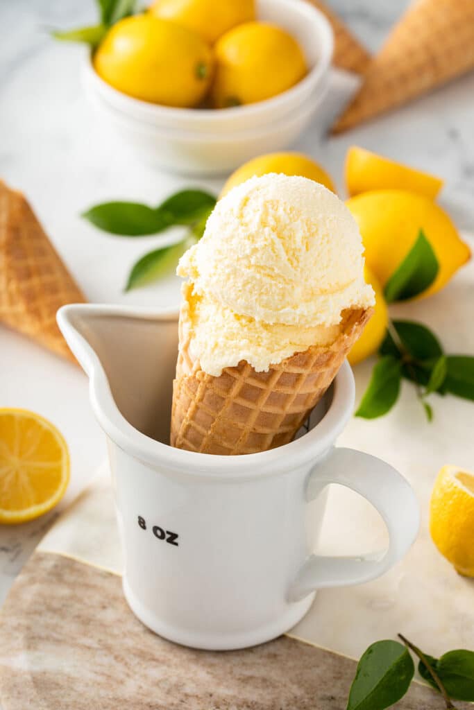 An ice cream cone with a scoop of fresh lemon ice cream.