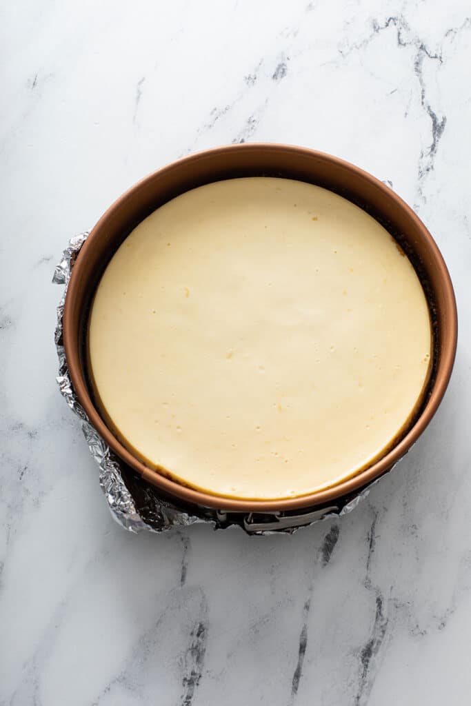 lemon cheesecake in a springform pan after it has been cooked in the oven.