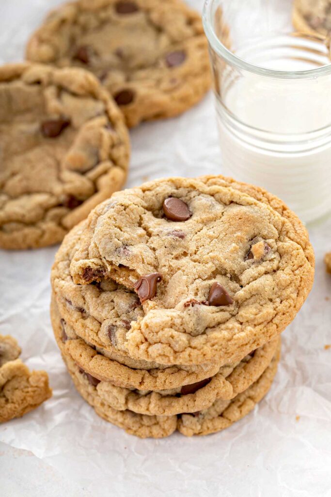 Stack of chocolate chip cookies next to a glass of milk