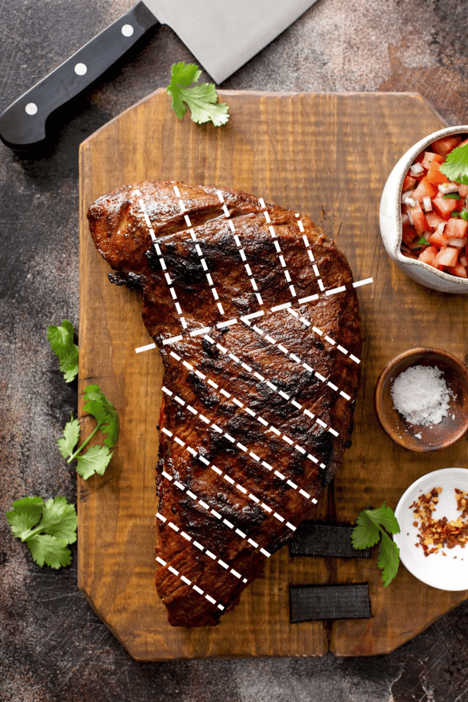 Photo of a grilled tri tip roast showing a diagram of how to slice the meat.
