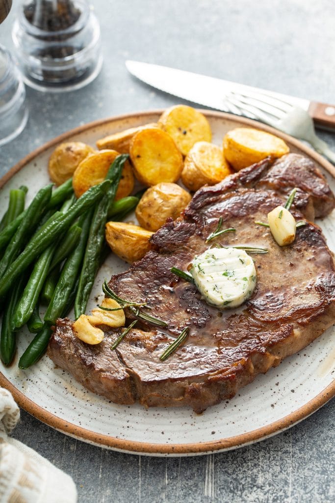 Perfectly seared golden brown steak served with roasted potatoes and green beans.