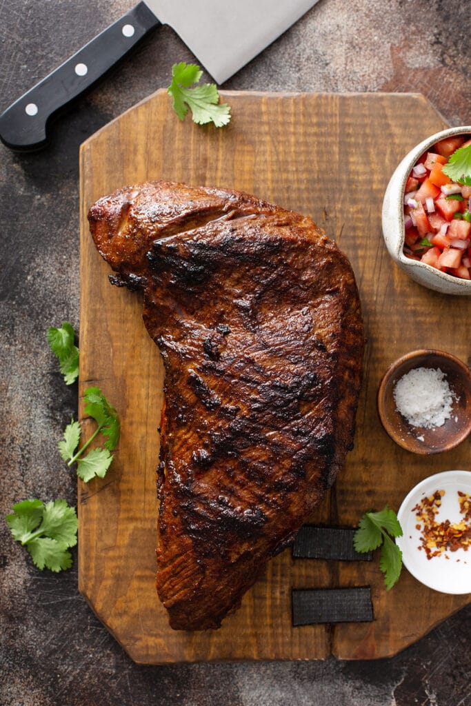 Juicy Santa Maria Style Tri-Tip Steak grilled to perfection resting on butcher block cutting board 
