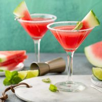 Martini glasses filled with watermelon marteni and garnished with watermelon wedges