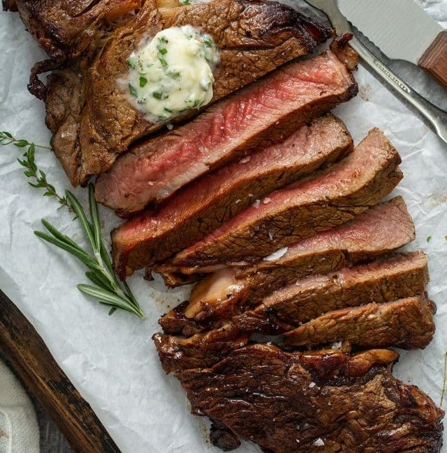 Golden brown steak sliced and topped with melty garlic butter.