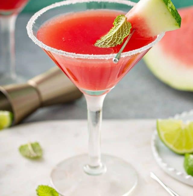 Watermelon Martini served in a martini glass and decorated with a piece of watermelon, sugar on the rim and a mint leaf.