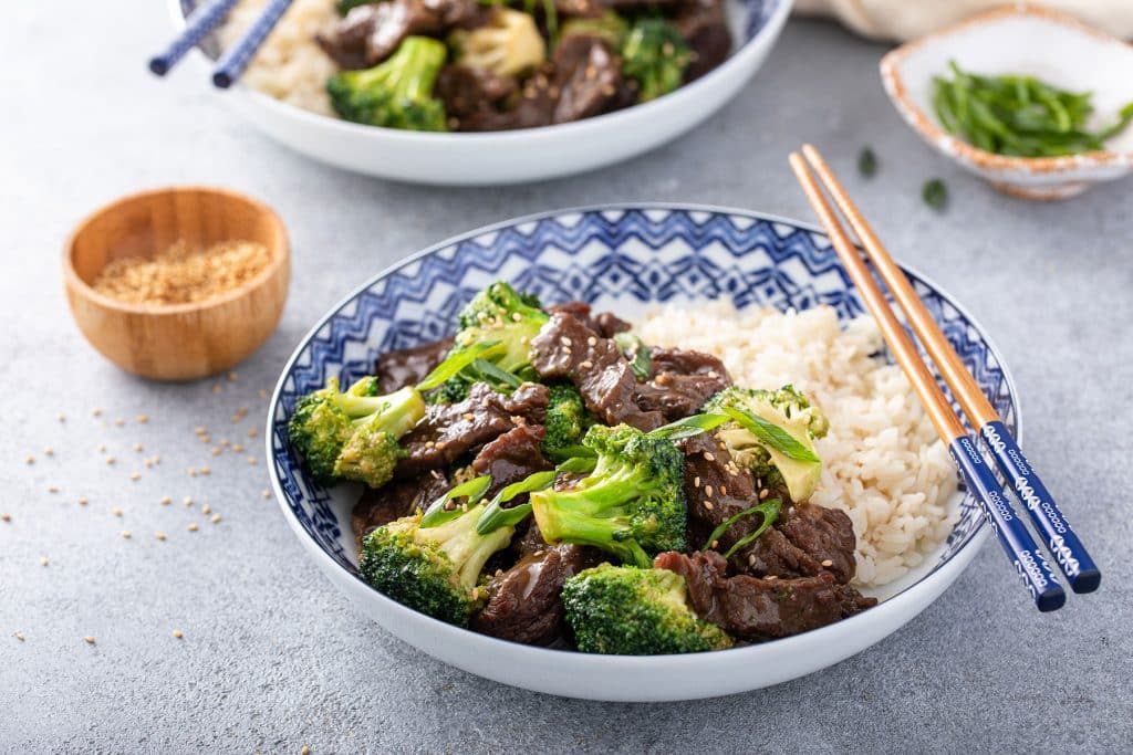 a bowl with beef and broccoli with white rice