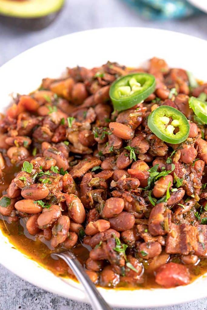 Charro Beans with bacon and cilantro served in a white serving bowl