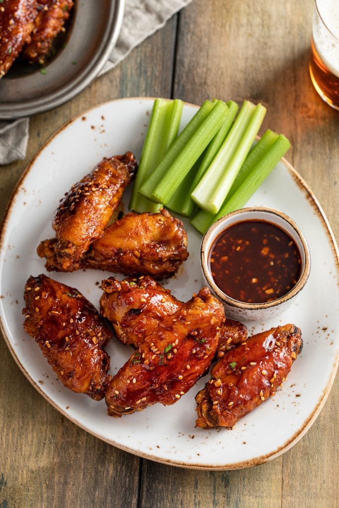 Chicken wings and Korean wing sauce served on a white plate.
