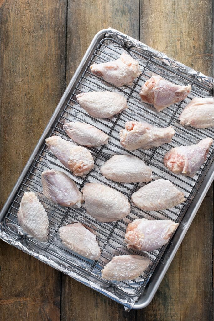 chicken wings lined up on a baking sheet