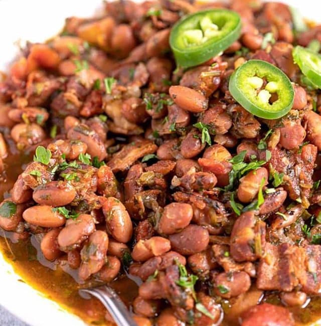 Charro Beans with bacon and cilantro served in a white serving bowl