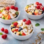 bowls of Bionicos Mexican fruit salad topped with sweet cream, granola and coconut.