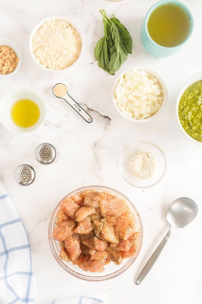 Ingredients to make Chicken Pesto Pasta over a marble surface