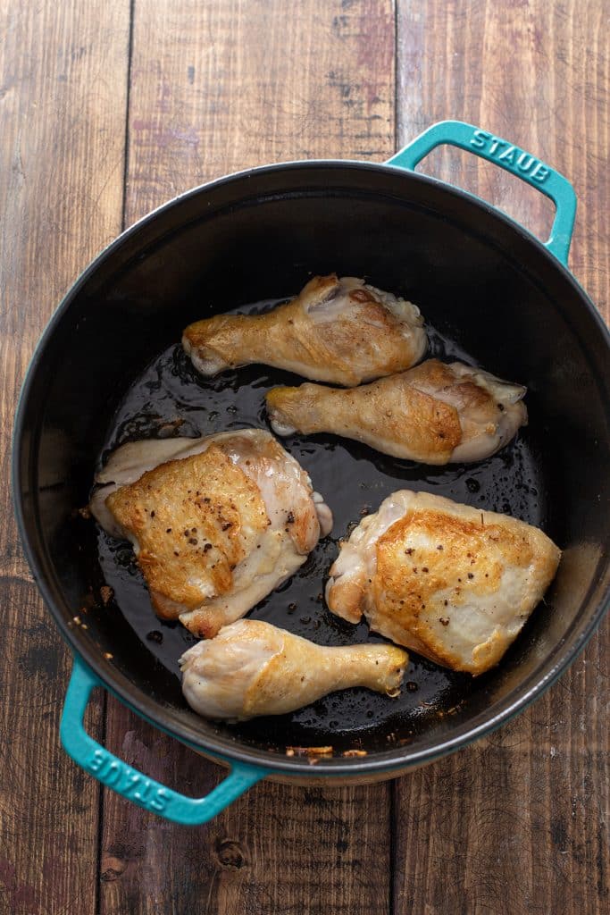 golden brown chicken legs and thighs on a pan