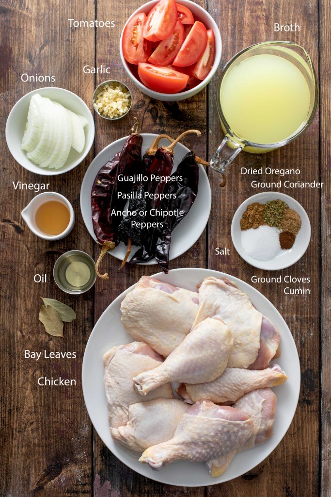 Ingredients to make Mexican Chicken Adodo over a wooden surface.
