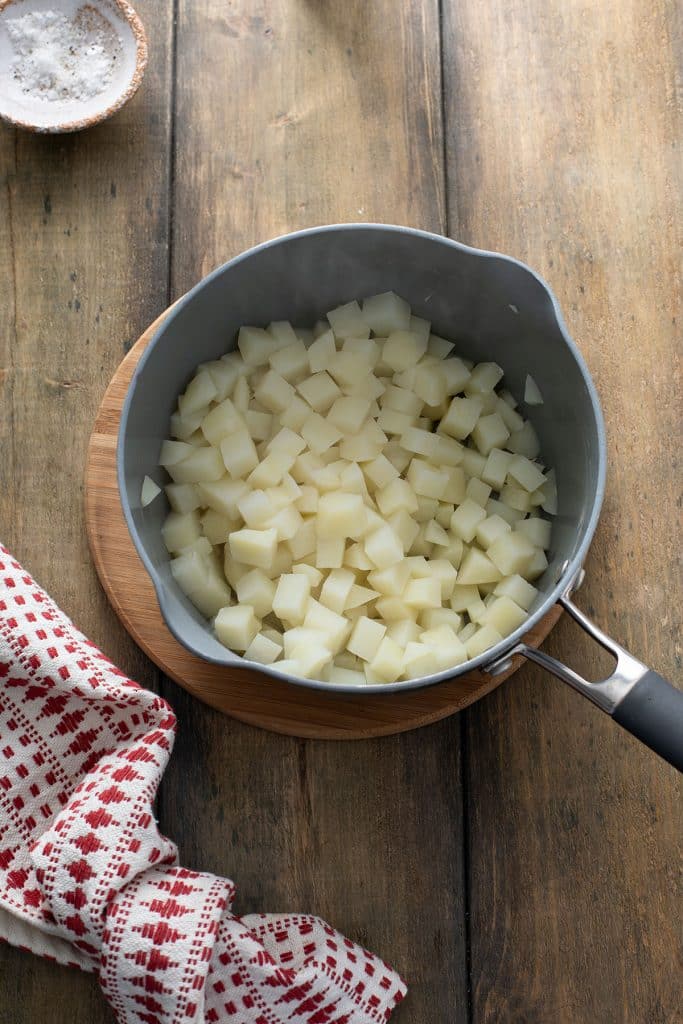 Diced potatoes that have been boiled in a pot. 