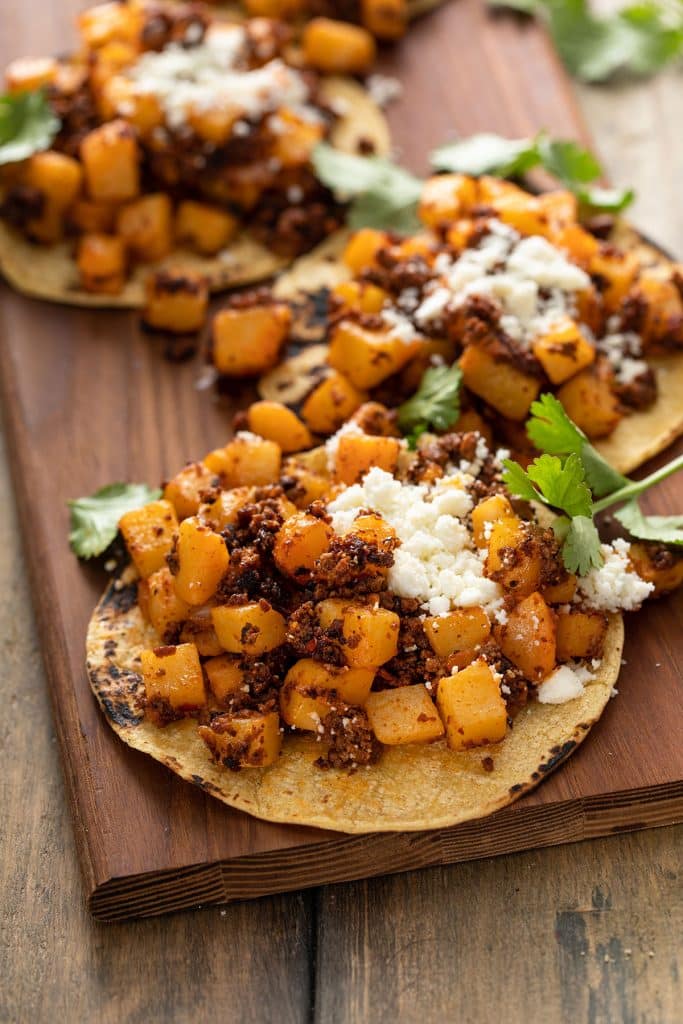 Potato and chorizo tacos on a corn tortilla topped with crumbled cheese