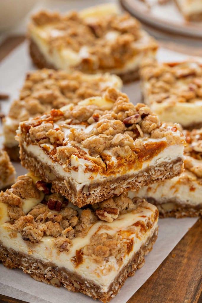 Swirl oat and pumpkin cheesecake bars on a piece of parchment paper.