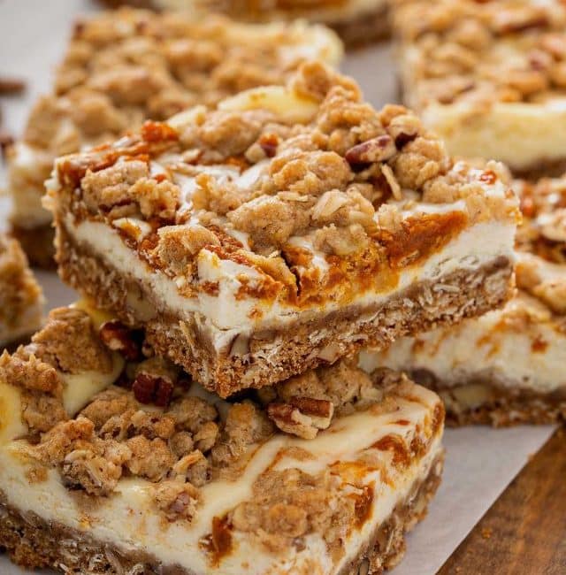 Swirl oat and pumpkin cheesecake bars on a piece of parchment paper.