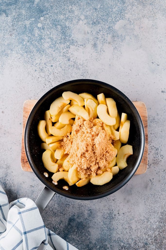 Apples sliced into bowl and brown sugar added. 