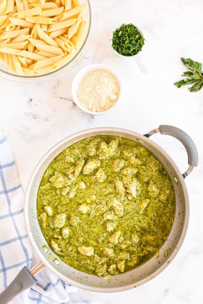 simmering the chicken cubes in the pesto sauce