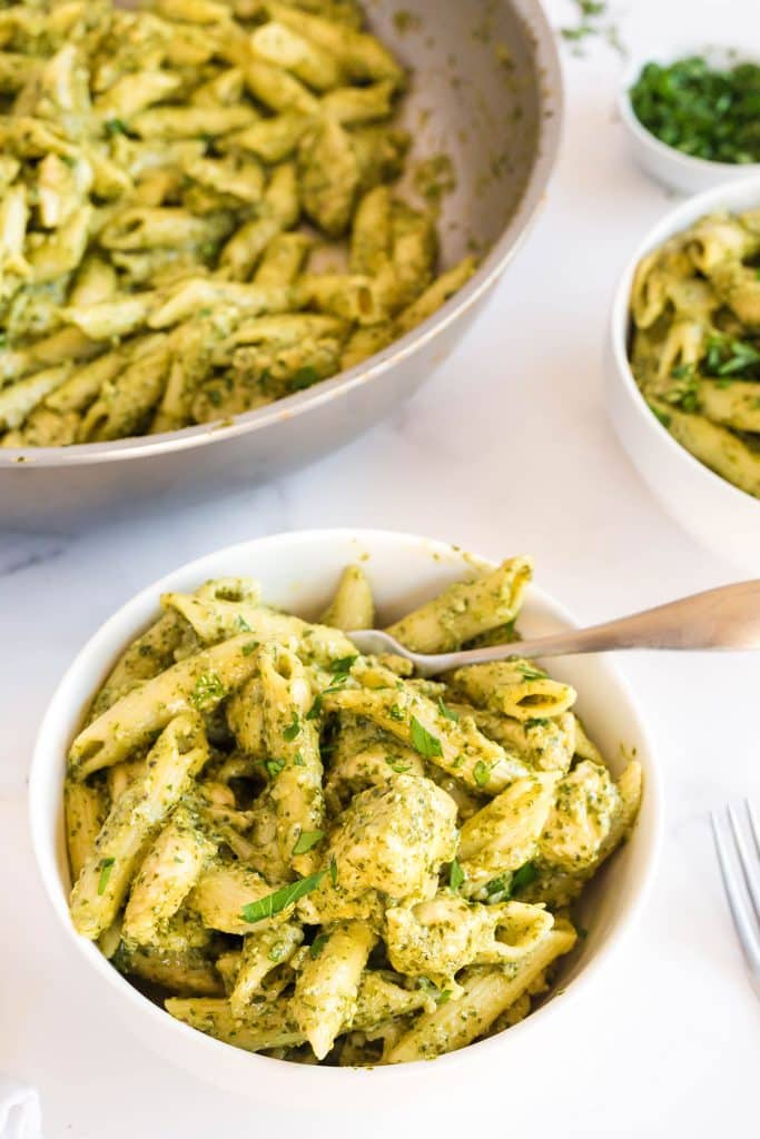 Chicken pesto pasta in a white serving bowl.