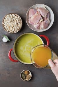 adding chicken broth to the green sauce