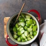 tomatillos cut in half over the sauteed chiles