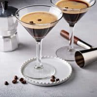Two espresso martinis garnished with coffee bean
