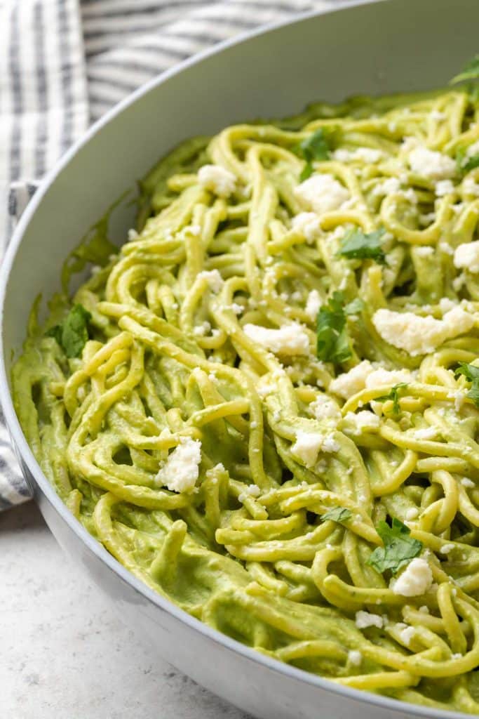 Creamy spaghetti with roasted poblano and cilantro sauce in a skillet.