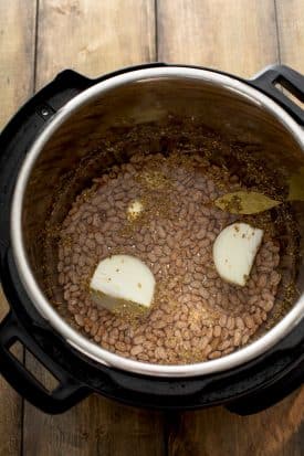 Instant Pot filled with ingredients for refried beans.
