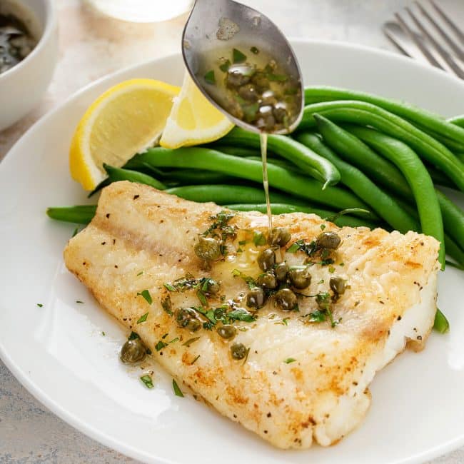 lemon butter and capers drizzled over light golden brown cod fish fillets