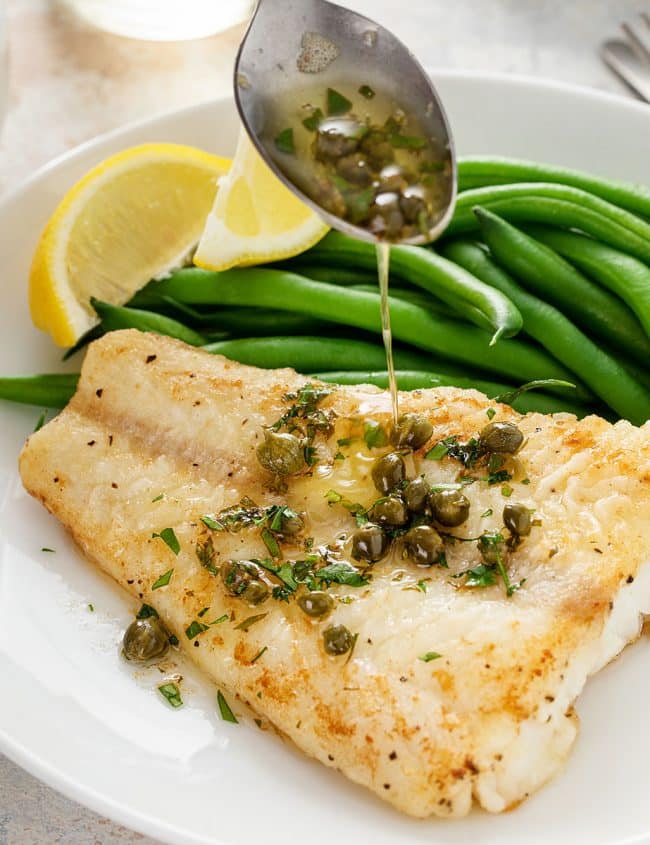 lemon butter and capers drizzled over light golden brown cod fish fillets