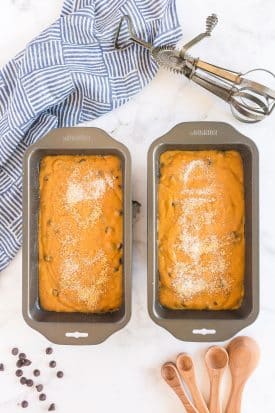 two baking loaf trays with chocolate chip pumpkin bread batter