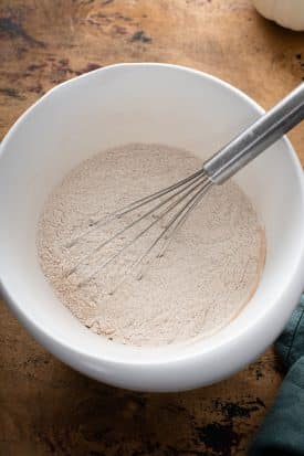 dry ingredients in a white bowl with a whisk