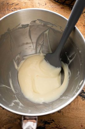 Smooth cream cheese frosting in the bowl of a stand mixer