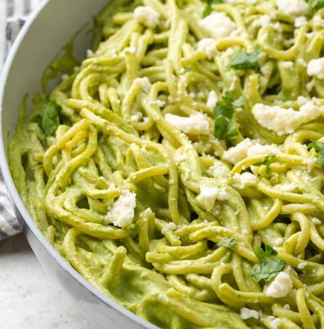 Creamy green spaghetti with roasted poblano and cilantro sauce in a skillet.