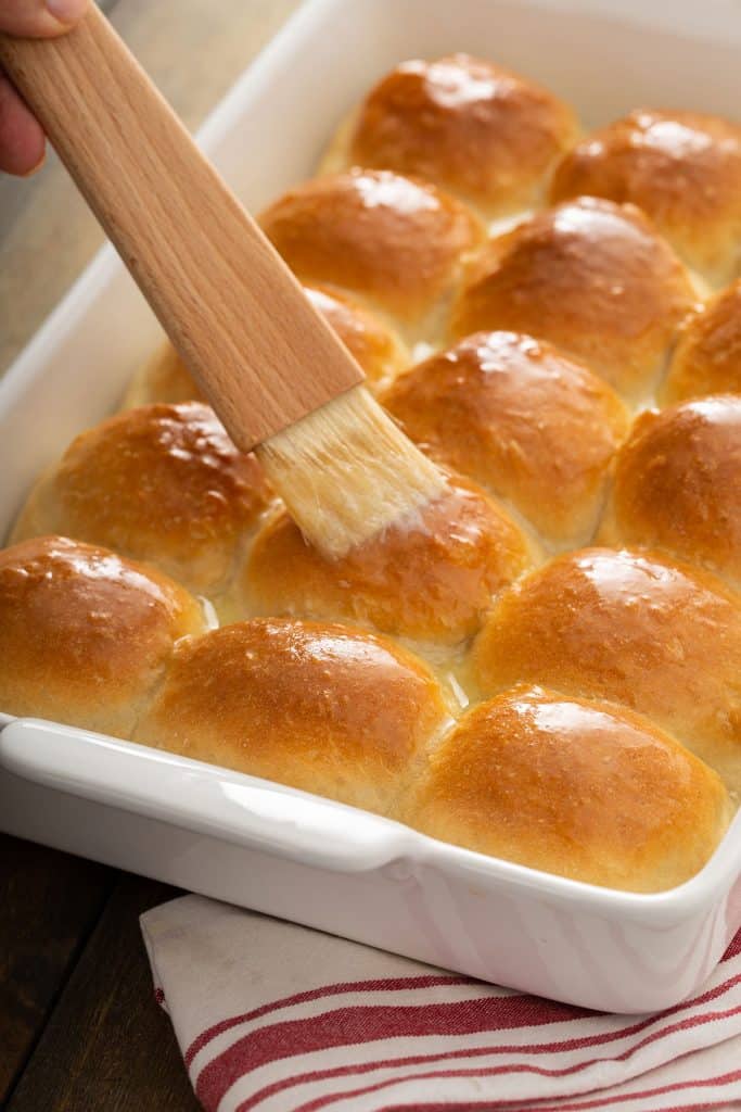 Dinner rolls getting brushed with butter