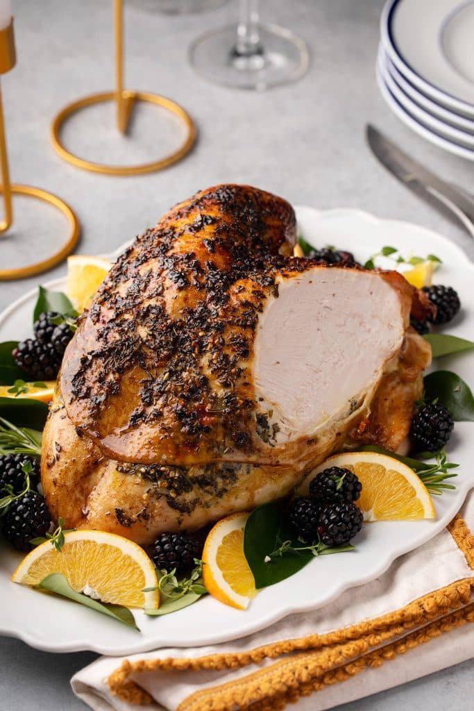 Golden brown turkey breast with a slice cut off showing the tender juicy turkey meat.