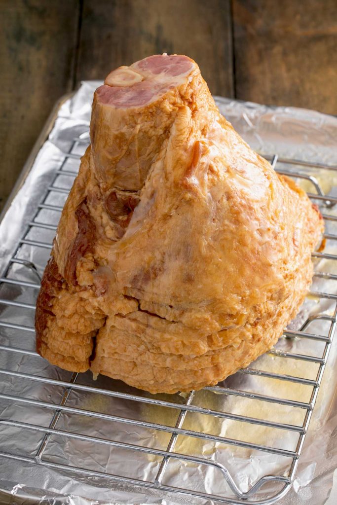 baked spiral ham on a baking sheet with a wire rack insert