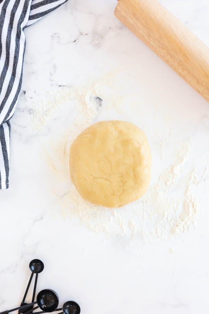 a disk of dough over a floured surface.