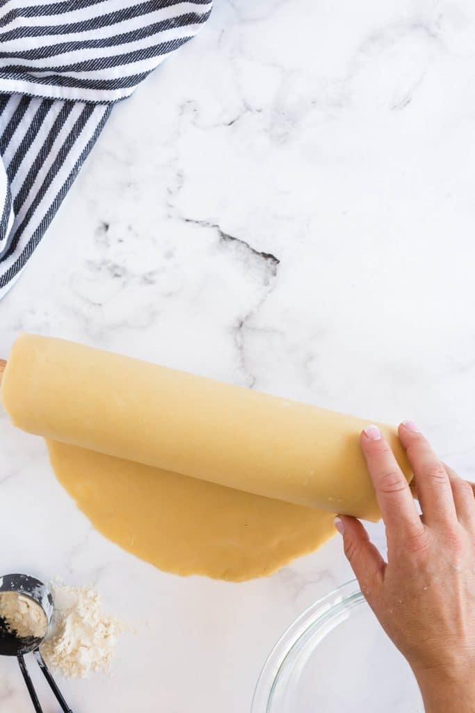 picking up the circle of dough with a rolling pin
