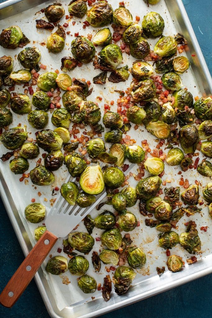 Golden Brussels sprouts and chopped pancetta on a sheet pan.