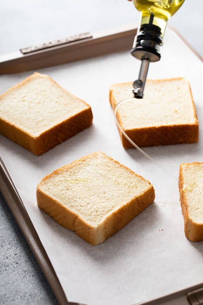 Drizzling oil over bread slices