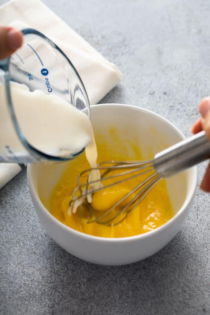 Tempering egg by pouring in warm sauce