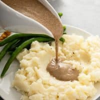 Pouring mushroom gravy over mashed potatoes