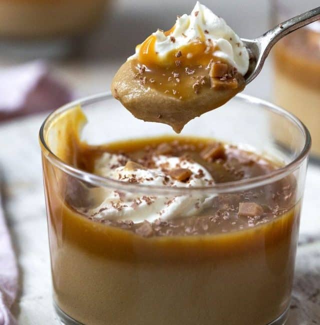 Scooping creamy Butterscotch Pudding out of a small glass.