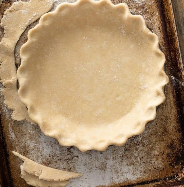 pie crust dough folded perfectly into the pie dish.