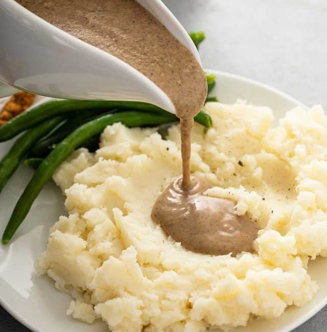 Pouring mushroom gravy over mashed potatoes